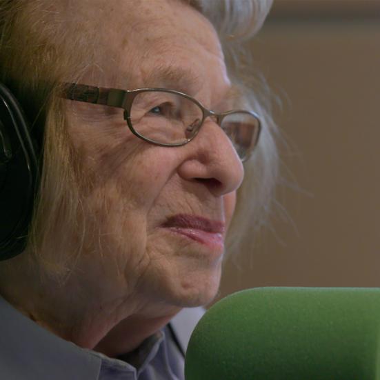 dr. ruth bliver interviewet foran en mikrofon og hun smiler
