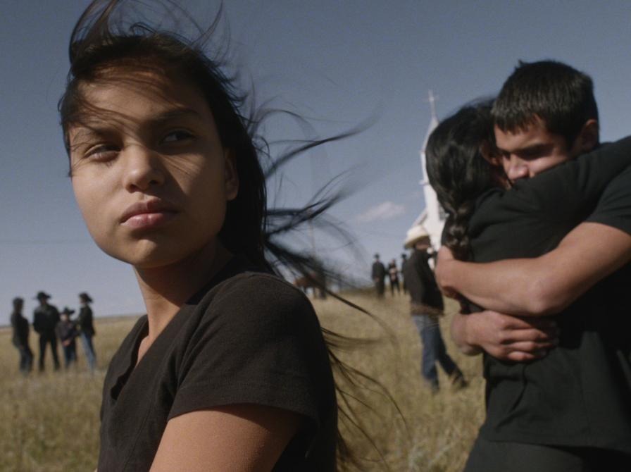 ung kvinde fra filmen i forgrunden, bagved hende er en mand og en dame i et kram